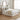 A white wooden platform bed with a headboard and storage drawers, styled with white and sage green bedding, a beige knit throw blanket, and neutral pillows in a bright, modern bedroom.